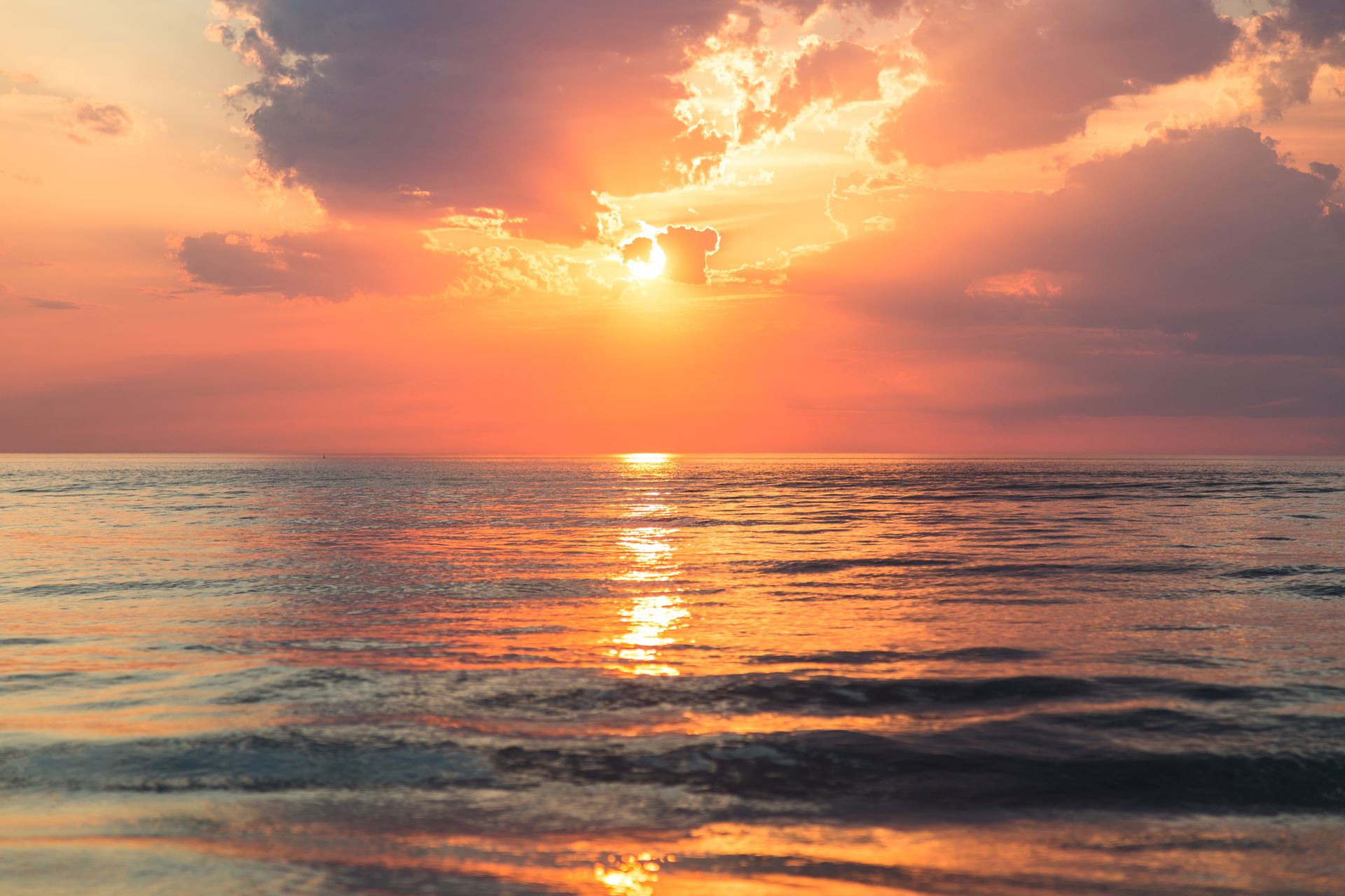 a sunset over a beach next to the ocean